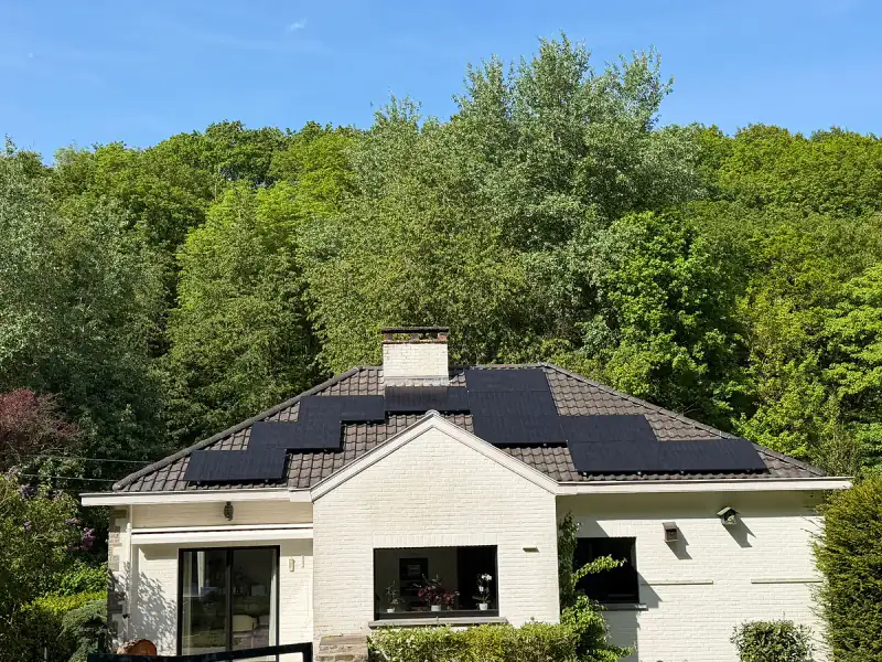 Maison blanche avec des panneaux solaires noirs sur le toit